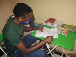 Teacher Allelua Christopher marking home study work (9)