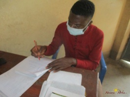 Teacher Bwambabale Gordwin  marking home study work (1)