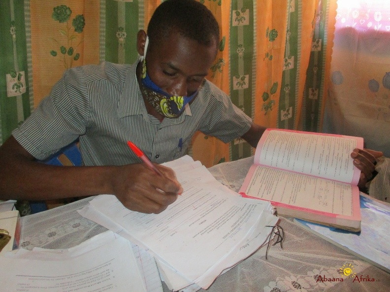 Teacher Byaruhanga Ronald marking home study work (4).JPG