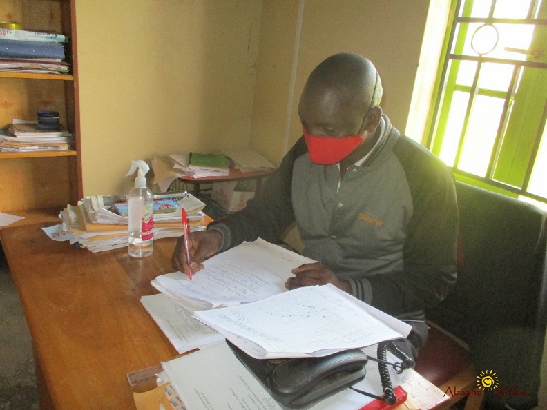 Teacher Irumba Deogratious marking home study work (12).JPG